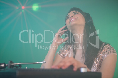 Pretty female DJ playing music