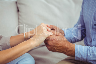 Close-up of man and woman holding hands