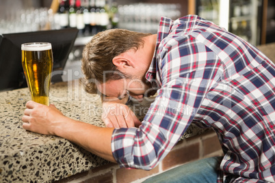 Exhausted man leaning his head on the counter