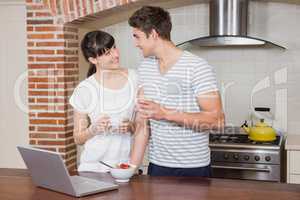 Young couple having coffee in kitchen