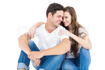 Young couple sitting on floor hugging