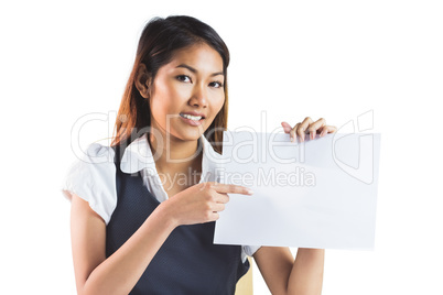 Smiling businesswoman pointing a sheet of paper