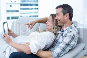 Expecting couple sitting on sofa