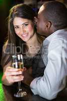 Man kissing woman at bar counter