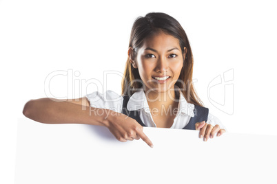 Smiling businesswoman pointing a white poster