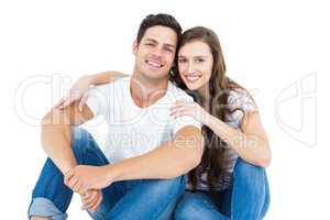 Young couple sitting on floor hugging