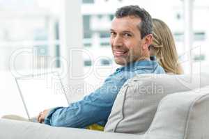 Couple sitting together and using laptop