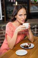 Pretty woman having coffee and brownie