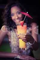 Young woman offering a cocktail at bar counter