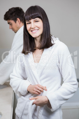 Woman looking at camera and man standing near sink