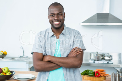 Man standing with arms crossed in kitchen