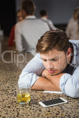 Tired man leaning on counter