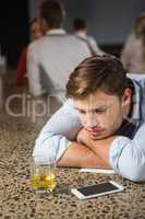 Tired man leaning on counter