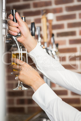 Masculine hands pouring beer