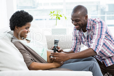 Man holding headphones on pregnant womans stomach
