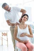 Doctor giving physiotherapy to pregnant woman