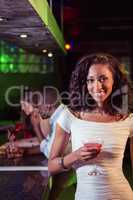 Young woman having cocktail at bar counter