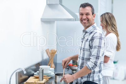 Man helping pregnant woman prepare food