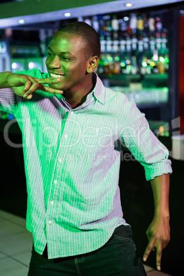 Happy man dancing in front of bar counter