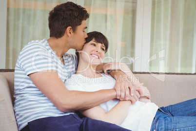 Young couple cuddling on sofa