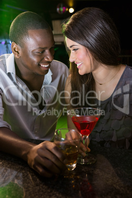 Couple looking at each other and smiling while having drinks
