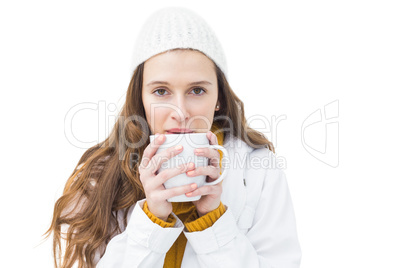 Pretty woman in winter clothes drinking a hot beverage