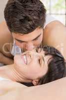 Man kissing woman on bed