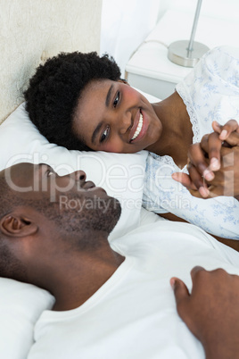 Pregnant couple relaxing on bed