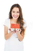 Happy woman holding miniature house