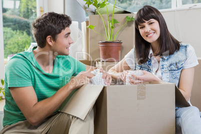 Young couple unpacking carton boxes in their new house