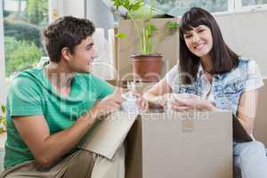 Young couple unpacking carton boxes in their new house