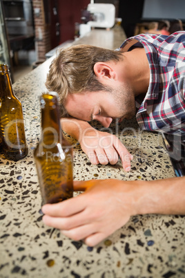 Exhausted man leaning his head on the counter