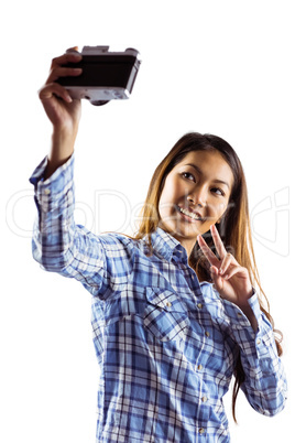 Smiling asian woman taking picture with camera