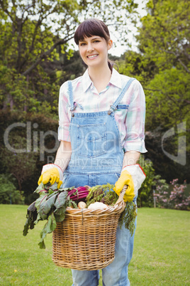 Woman holding a basket of freshly harvested vegetables