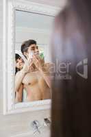 Young woman applying shaving cream on young mans face