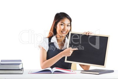 Smiling businesswoman pointing a blackboard