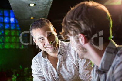 Happy men talking near a bar counter