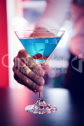 Bartender serving a blue martini