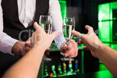 Bartender serving glass of champagne Bartender serving glass of champagne