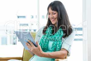 Pregnant woman using digital tablet