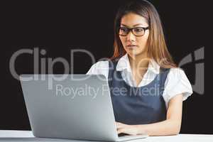 Serious businesswoman using laptop