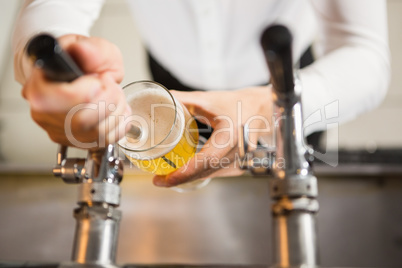 Masculine hands pouring a pint