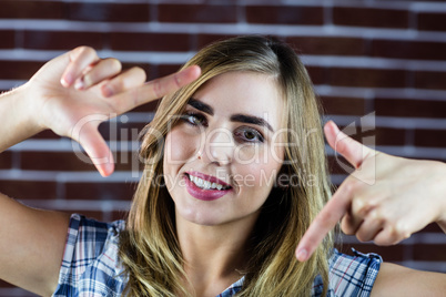 Pretty blonde woman making signs with her fingers