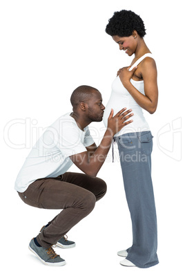 Man kissing the belly of pregnant woman