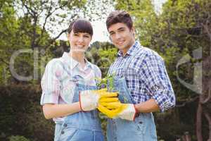 Young couple holding a sapling