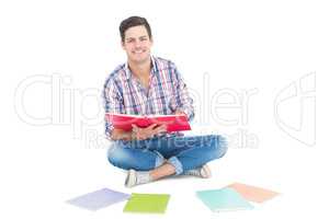 Man reading a book while sitting on the floor