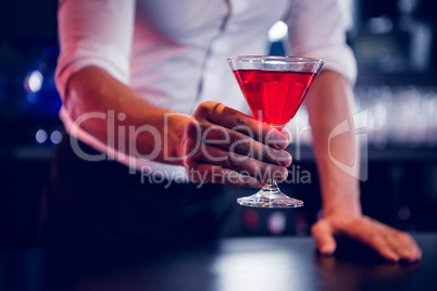 Bartender serving a red martini