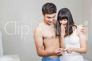 Happy couple checking results of pregnancy test