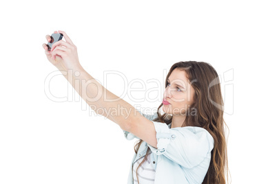 Smiling young woman taking a selfie while grimacing