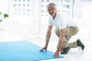 Physiotherapist laying exercise mat
